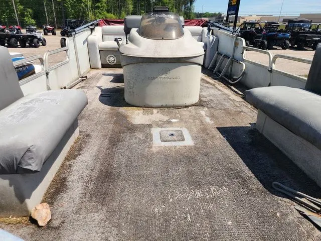 Slide: The Image of 1998 Sun Tracker BASS BUGGY 18 pontoon boat, worn deck, seating benches, outdoors. - 5