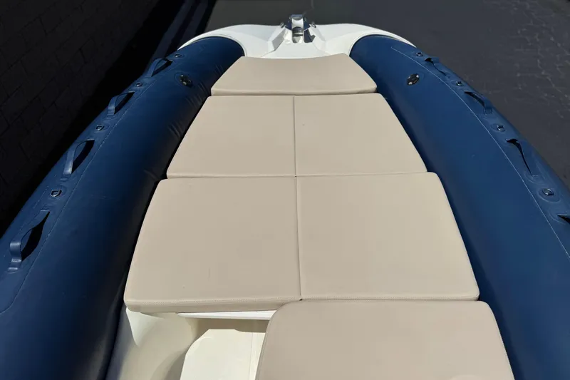 Slide: The Image of 2021 Zodiac N-ZO 680 boat with beige seating and blue inflatable sides. - 11