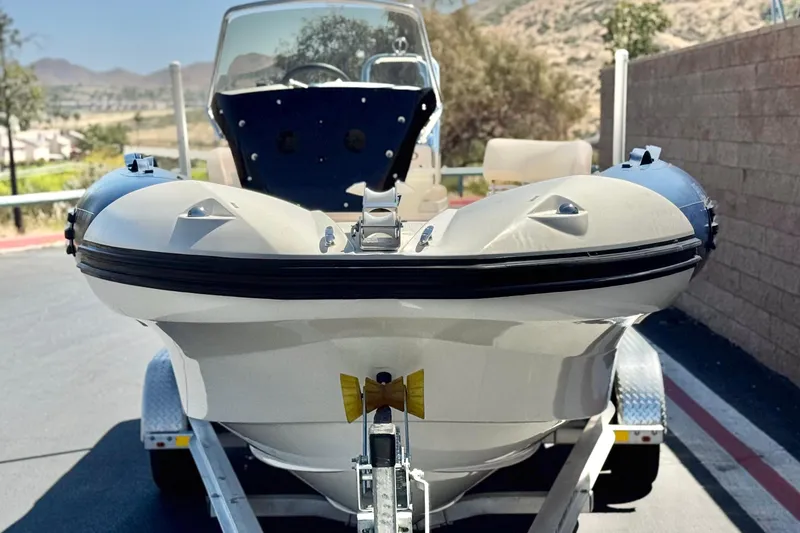 Slide: The Image of 2021 Zodiac N-ZO 680 boat on trailer, parked outdoors with scenic background. - 2