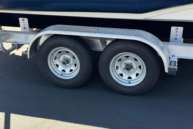 Slide: The Image of Trailer wheels for 2021 Zodiac N-ZO 680 boat on asphalt surface. - 23