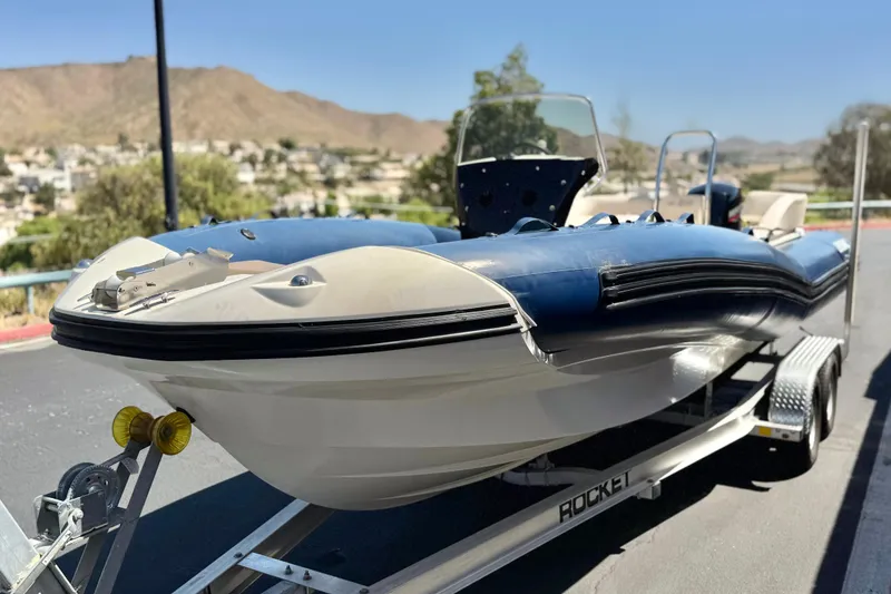 Slide: The Image of 2021 Zodiac N-ZO 680 boat on trailer, parked outdoors with scenic background. - 3