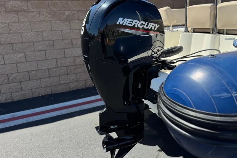 Slide: The Image of 2021 Zodiac N-ZO 680 boat with Mercury outboard motor, parked near a brick wall. - 6
