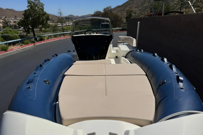 Slide: The Image of 2021 Zodiac N-ZO 680 boat with blue inflatable tubes and beige seating, parked outdoors. - 9