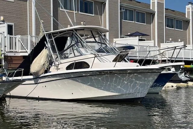 The Image of 2005 Grady White 282 Sailfish boat docked near waterfront homes. - 0