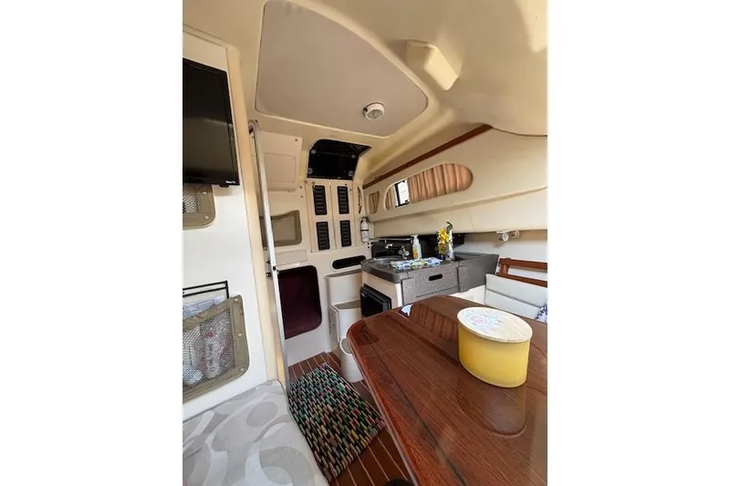 Slide: The Image of Interior of 2005 Grady White 282 Sailfish boat, featuring cozy cabin and kitchenette. - 10