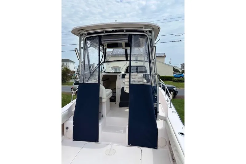 Slide: The Image of 2005 Grady White 282 Sailfish boat with blue canvas enclosure, docked outdoors. - 3