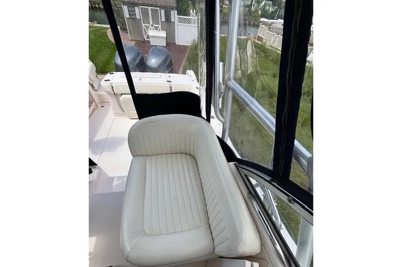 Slide: The Image of 2005 Grady White 282 Sailfish boat interior with cushioned seating and clear enclosure. - 6