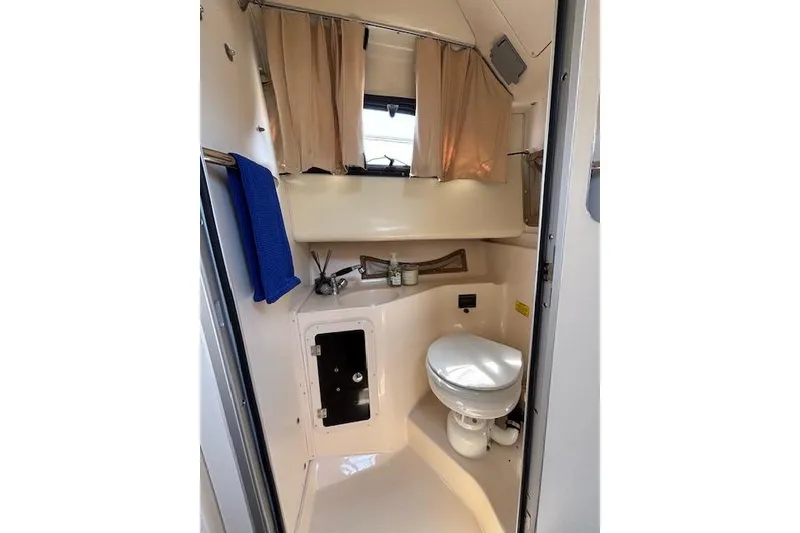 Slide: The Image of 2005 Grady White 282 Sailfish boat bathroom with toilet, sink, and window. - 9