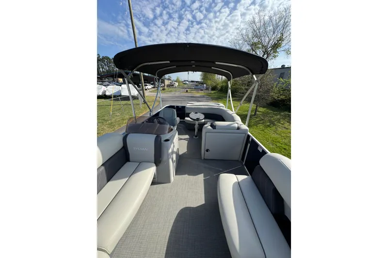 Slide: The Image of 2023 Sylvan Mirage 820 Cruise pontoon boat with spacious seating and canopy under a blue sky. - 13