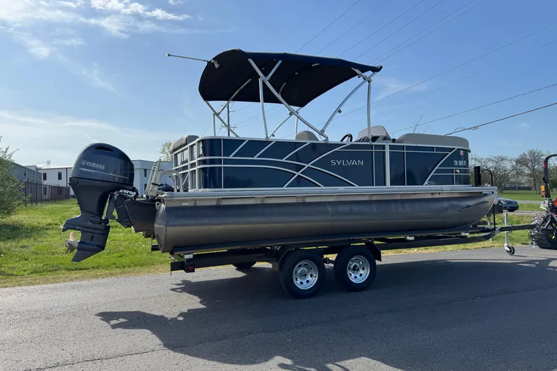 Slide: The Image of 2023 Sylvan Mirage 820 Cruise pontoon boat on trailer, featuring Yamaha outboard motor. - 14