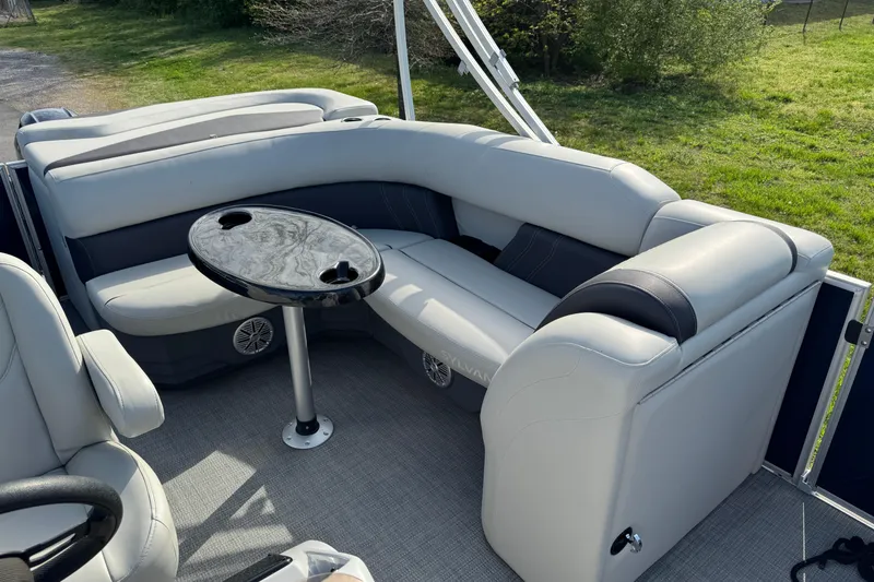 Slide: The Image of 2023 Sylvan Mirage 820 Cruise interior with plush seating and a sleek table. - 8