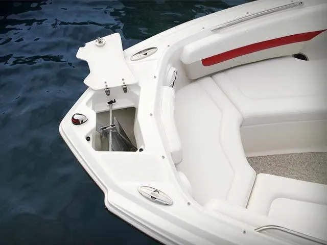 Slide: The Image of 2011 Chaparral 216 SSi boat with open anchor compartment on calm water. - 3