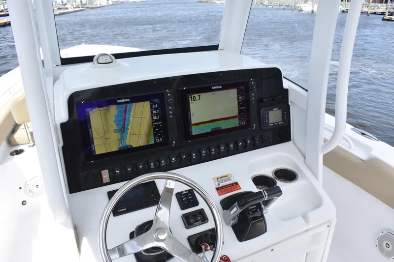 Slide: The Image of 2017 Sea Hunt Gamefish 27 dashboard with navigation screens and steering wheel. - 13