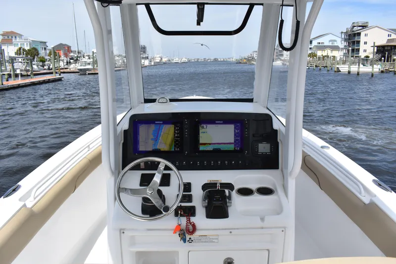 Slide: The Image of 2017 Sea Hunt Gamefish 27 boat dashboard with navigation screens and steering wheel. - 14