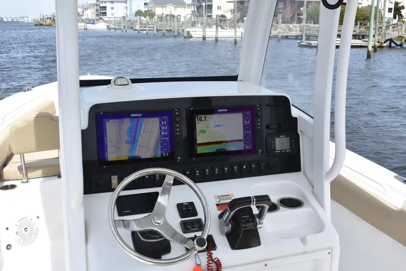 Slide: The Image of 2017 Sea Hunt Gamefish 27 helm with dual Simrad displays, steering wheel, and throttle controls. - 16