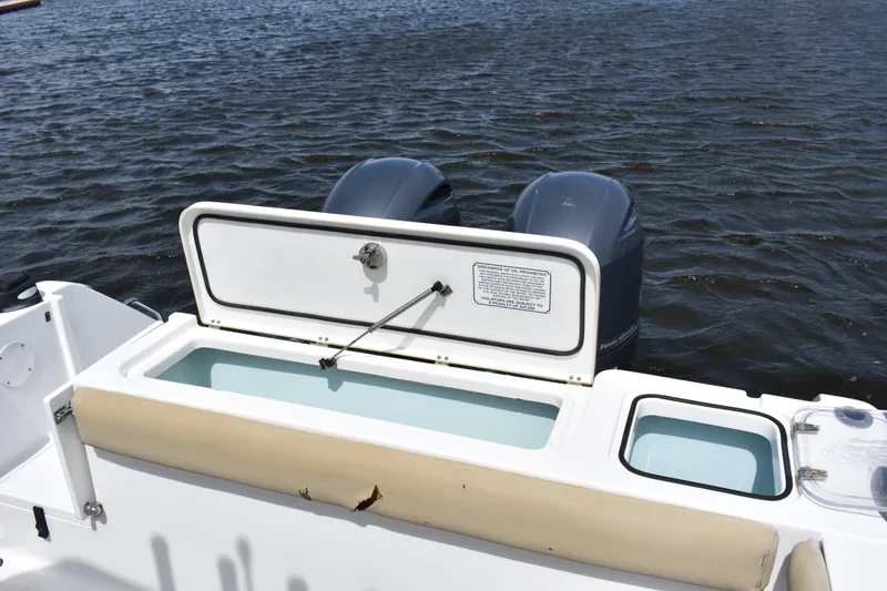 Slide: The Image of 2017 Sea Hunt Gamefish 27 boat with open storage compartment and twin engines on water. - 21