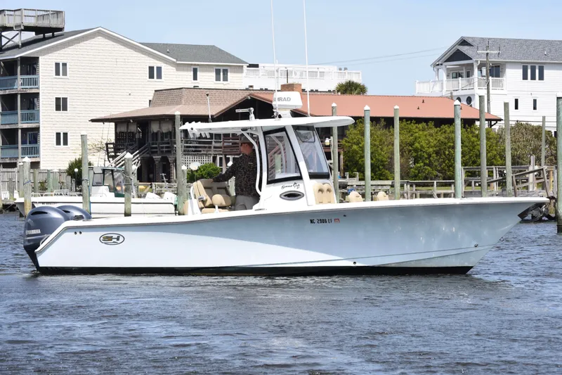 Slide: The Image of 2017 Sea Hunt Gamefish 27 boat with forward seating on a calm waterfront. - 4