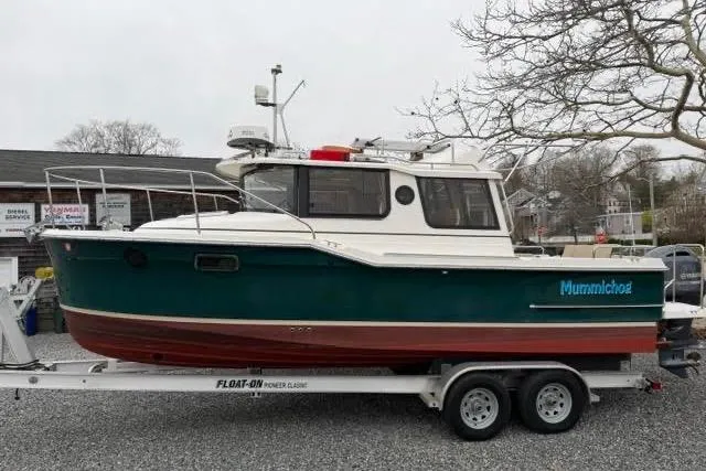The Image of 2020 Ranger Tugs R-23 boat on trailer, green and white exterior, parked outdoors. - 0