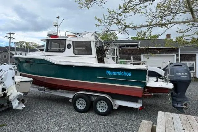Slide: The Image of 2020 Ranger Tugs R-23 boat on trailer with Yamaha outboard motor, parked outdoors. - 1