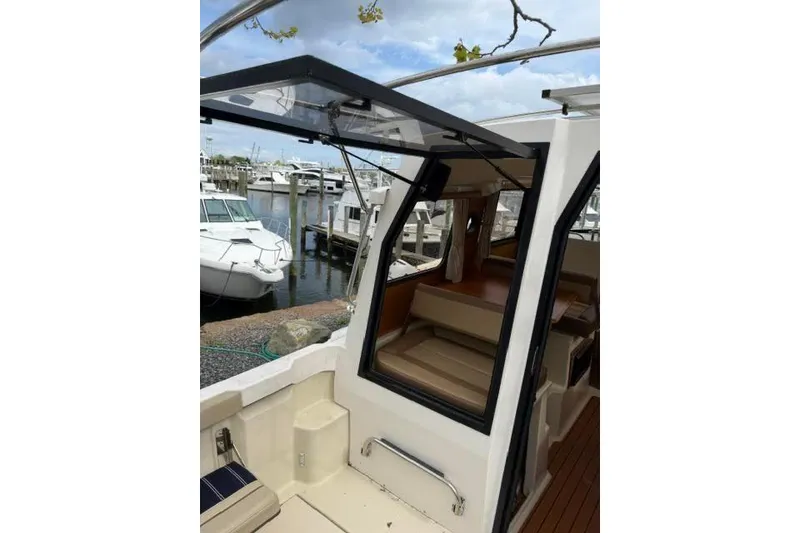 Slide: The Image of 2020 Ranger Tugs R-23 boat interior with open cabin door at marina. - 10