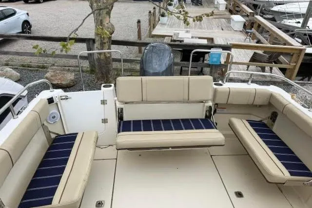 Slide: The Image of 2020 Ranger Tugs R-23 boat interior with beige and navy seating, docked at marina. - 12