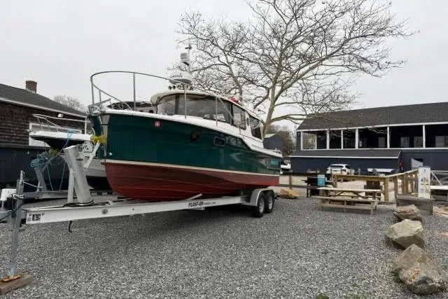 Slide: The Image of 2020 Ranger Tugs R-23 boat on trailer, parked outdoors near buildings. - 2