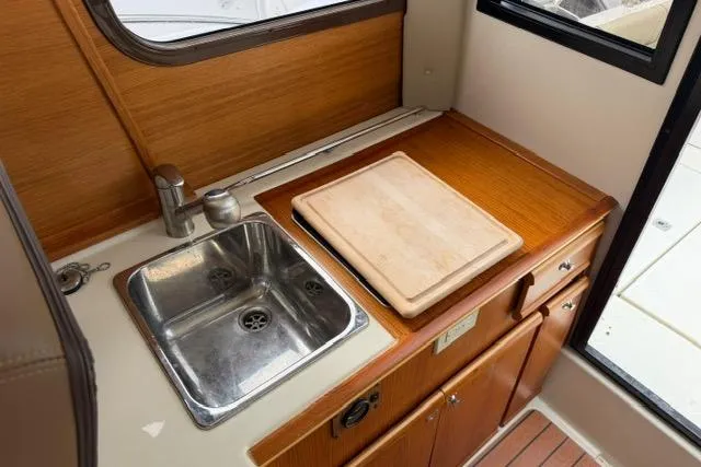 Slide: The Image of Compact kitchen area in a 2020 Ranger Tugs R-23 boat with sink and cutting board. - 24