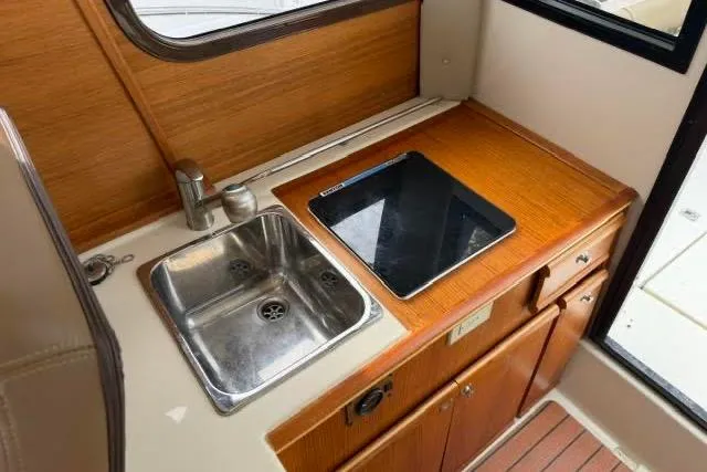 Slide: The Image of 2020 Ranger Tugs R-23 boat interior with sink and stove in compact kitchen area. - 25
