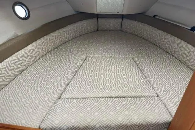 Slide: The Image of 2020 Ranger Tugs R-23 cabin interior with patterned cushions and porthole window. - 28