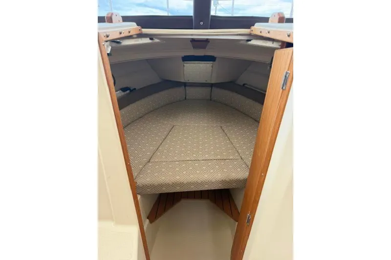 Slide: The Image of 2020 Ranger Tugs R-23 cabin interior with cushioned seating and wooden accents. - 29