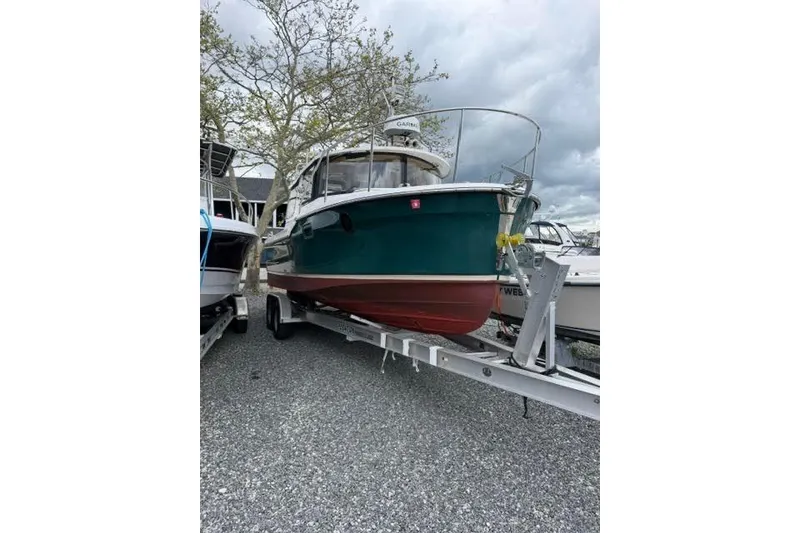 Slide: The Image of 2020 Ranger Tugs R-23 boat on trailer, green hull, overcast sky background. - 3