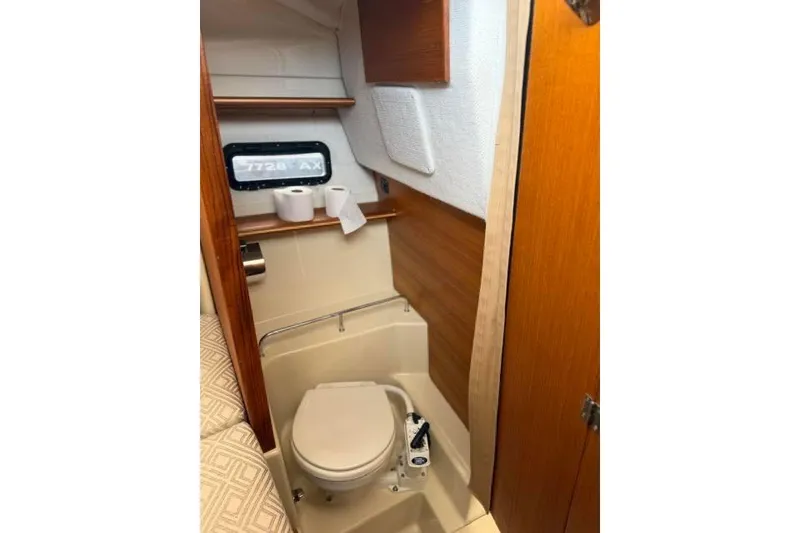 Slide: The Image of 2020 Ranger Tugs R-23 boat bathroom with compact toilet and wooden accents. - 30