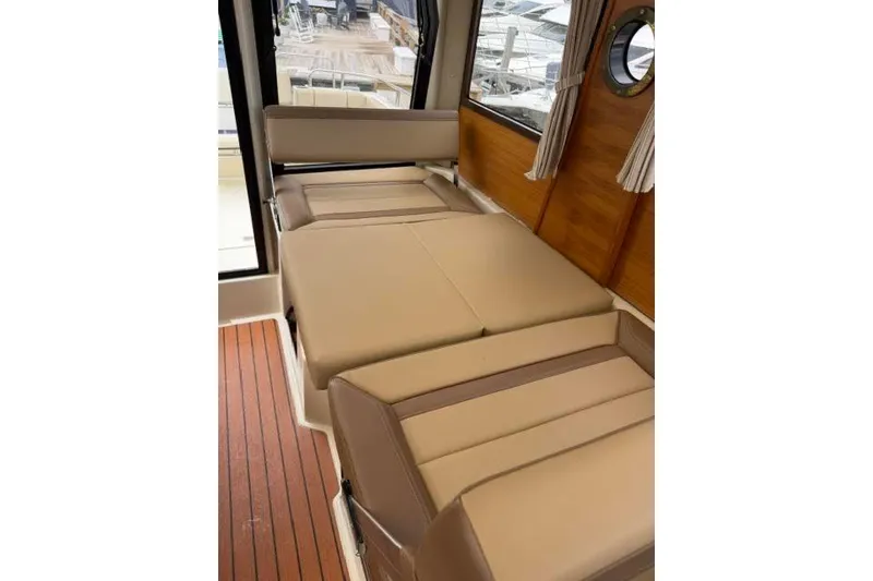 Slide: The Image of 2020 Ranger Tugs R-23 interior with beige seating and wooden accents. - 31