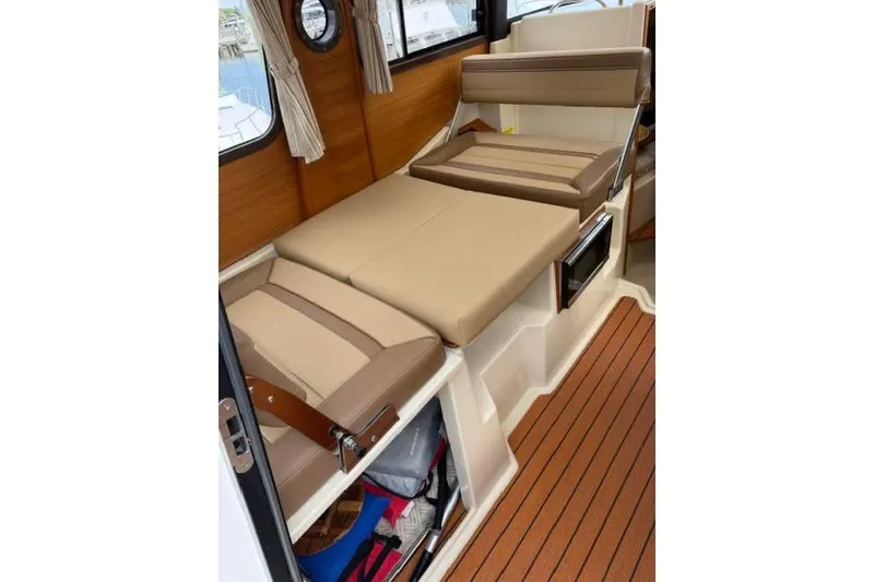 Slide: The Image of Interior of 2020 Ranger Tugs R-23 boat with beige seating and wood accents. - 32