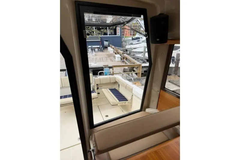 Slide: The Image of Interior view of 2020 Ranger Tugs R-23 boat, showcasing seating and dockside scenery. - 33