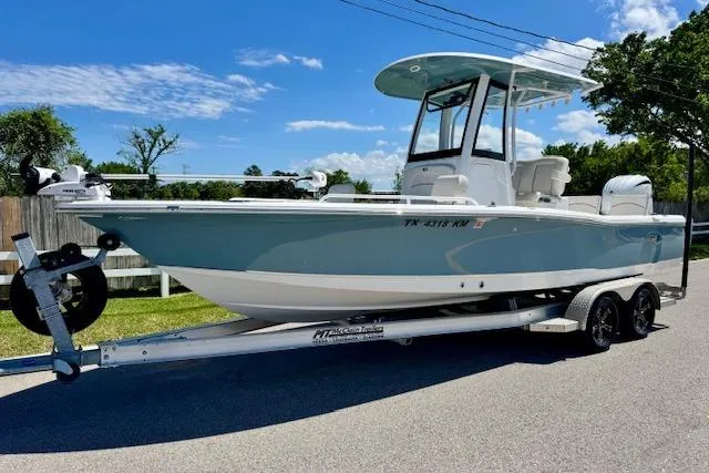 The Image of 2022 Sea Hunt BX 25 FS boat on trailer, parked on a sunny street. - 1