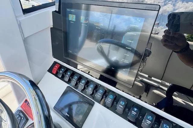 Slide: The Image of 2022 Sea Hunt BX 25 FS boat dashboard with touchscreen and control switches. - 17