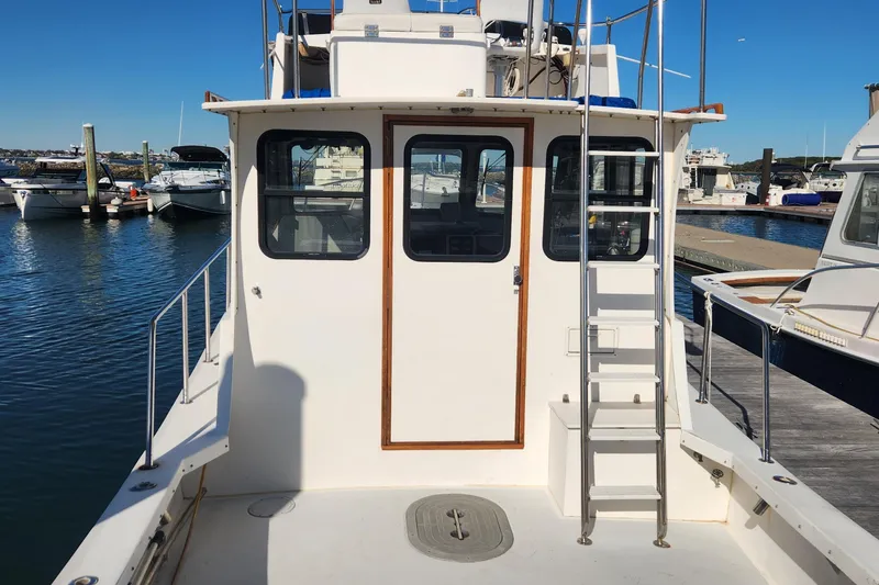 Slide: The Image of 2001 Eastern 31 Casco Bay boat docked at marina, rear view with ladder and windows. - 5