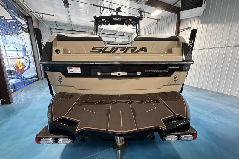 Slide: The Image of 2023 Supra SE 550 boat rear view in showroom, featuring Swell Surf system. - 5