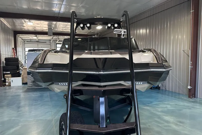 Slide: The Image of 2023 Supra SE 550 boat in a storage facility, front view with trailer ladder. - 8