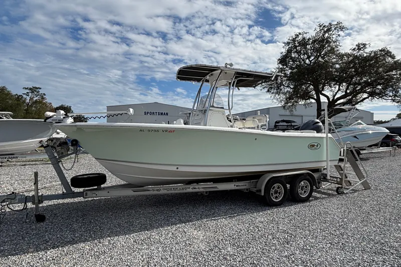 The Image of 2016 Sea Hunt Ultra 225 boat on trailer, parked outdoors under cloudy sky. - 0