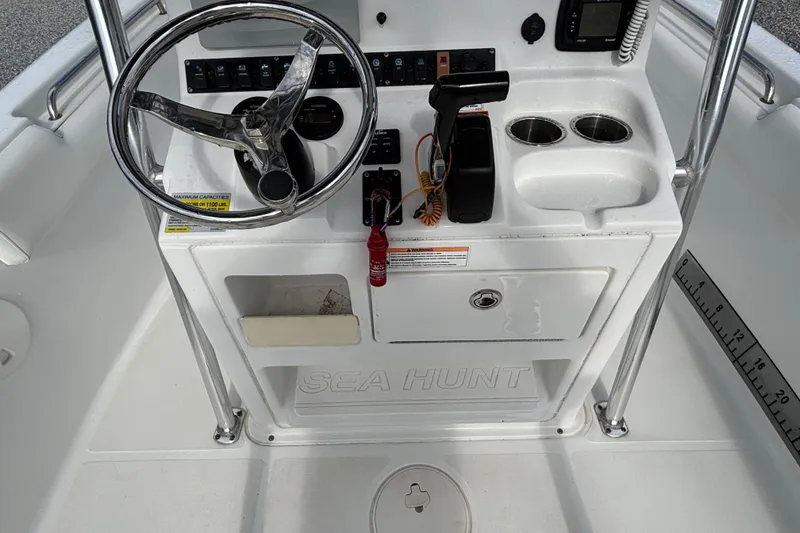 Slide: The Image of Steering console of a 2016 Sea Hunt Ultra 225 boat with controls and cup holders. - 17