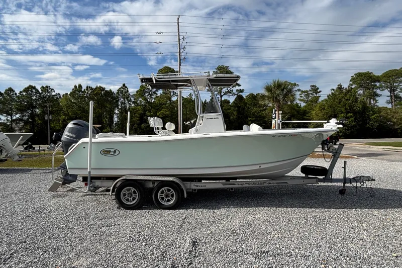 Slide: The Image of 2016 Sea Hunt Ultra 225 boat on trailer, parked outdoors under a blue sky. - 2