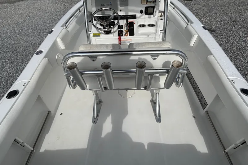 Slide: The Image of 2016 Sea Hunt Ultra 225 boat interior with steering console and rod holders. - 21