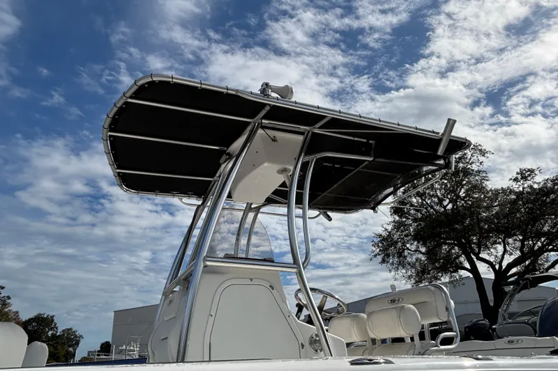Slide: The Image of 2016 Sea Hunt Ultra 225 boat with T-top under a partly cloudy sky. - 23