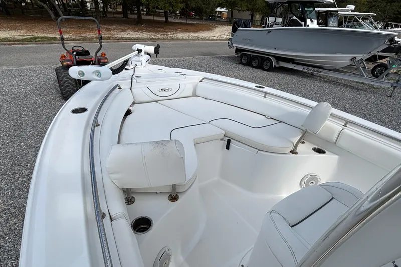 Slide: The Image of 2016 Sea Hunt Ultra 225 boat interior with seating, parked on gravel near a trailer. - 5