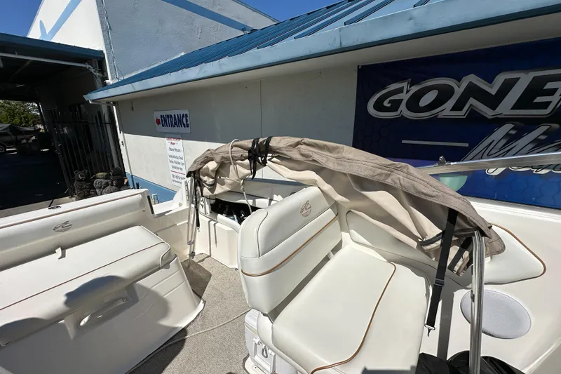 Slide: The Image of 1998 Sea Ray 215 Express Cruiser interior with white seating and folded canopy. - 10