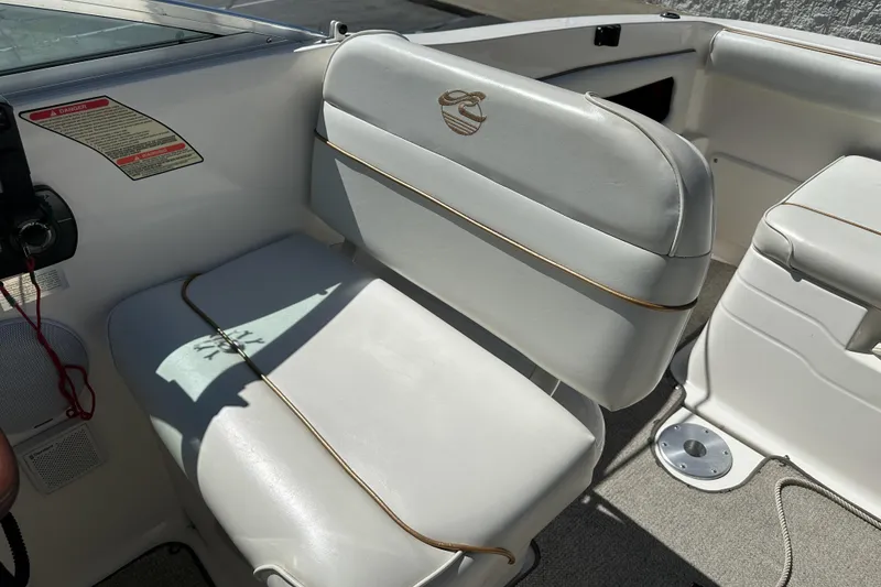 Slide: The Image of 1998 Sea Ray 215 Express Cruiser interior with white seating and control panel. - 19
