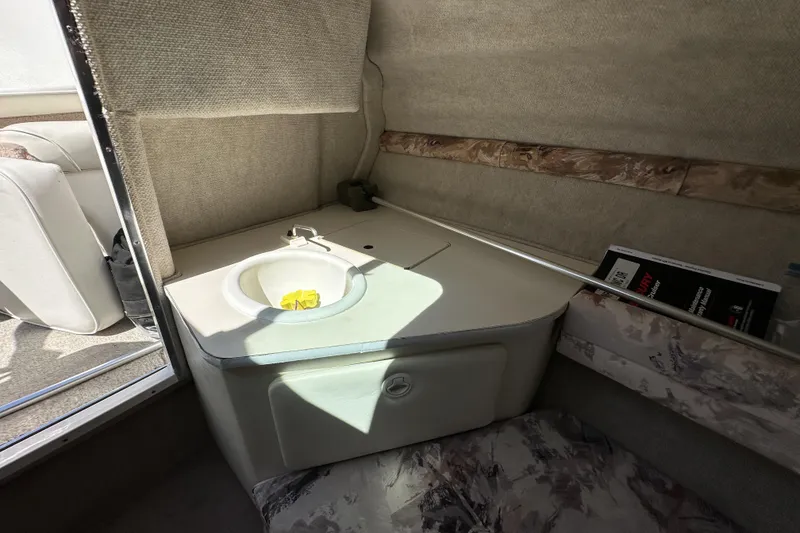 Slide: The Image of Interior of a 1998 Sea Ray 215 Express Cruiser with a compact sink and seating area. - 22