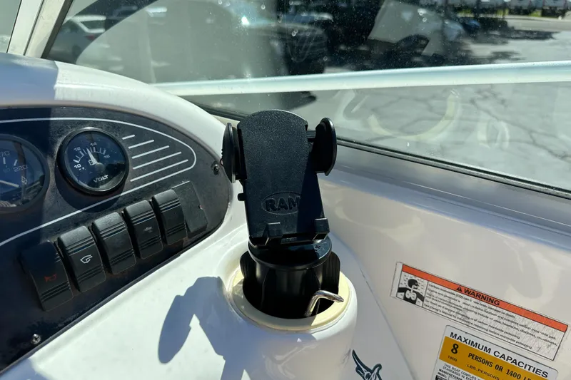 Slide: The Image of Dashboard of a 1998 Sea Ray 215 Express Cruiser with gauges and a phone mount. - 25